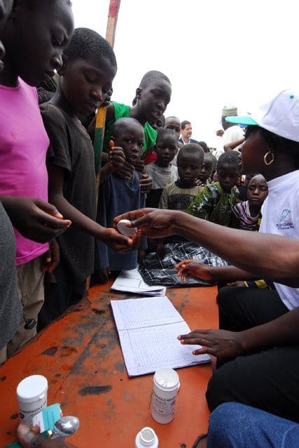 A health worker recording medication in a paper register