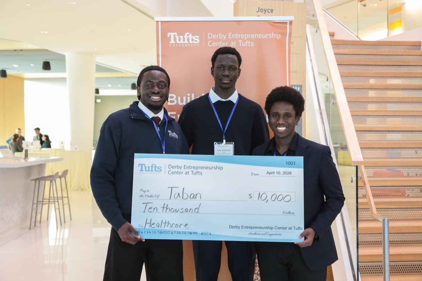 Toye Adebayo, Teny Makuach and Ekow Williams holding the $10,000 check at the Derby Entrepreneurship Center at Tufts